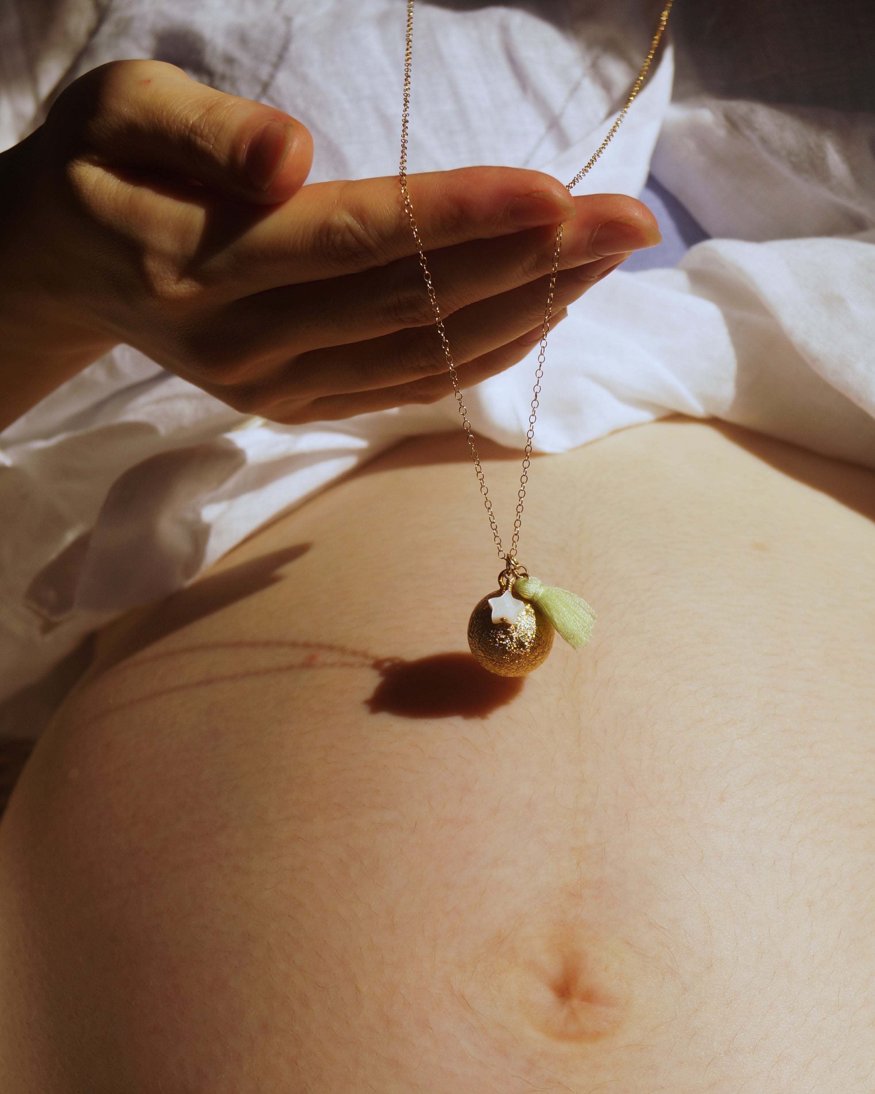 Bo-emeのマタニティネックレス、ゴールドボラと星チャーム付き。妊婦のお腹に寄り添い、胎教、安産祈願、ヨガプレナタル、出産祝い、ベビーシャワー、妊婦ファッション、写真撮影やベリーペイントにも活用できるジュエリー。妊娠中は胎動や妊娠報告の喜びに満ち、出産準備を進めながら栄養や妊娠中の食事に気を使います。スキンケアやマタニティウェア、妊婦帯も大切。妊婦マークや母子健康手帳を持ち歩き、胎教や安産祈願のために、胎教ネックレスや安産祈願ネックレス、お守りネックレス、ガムランボール、ハーモニーボールを取り入れましょう。妊婦の生活は妊娠報告、胎動の喜びから始まり、出産準備や栄養、妊娠中の食事、スキンケアに続きます。マタニティウェアや妊婦帯、妊婦マークや母子健康手帳が必需品。そこに胎教ネックレス、安産祈願ネックレス、お守りネックレス、ガムランボール、ハーモニーボールを加えれば、より豊かな妊娠期が過ごせます。